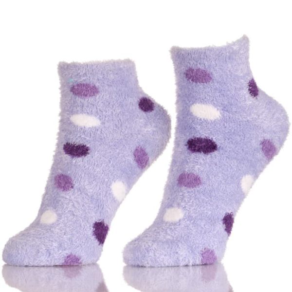 Par de calcetines tobilleros peludos con lunares morados y blancos.