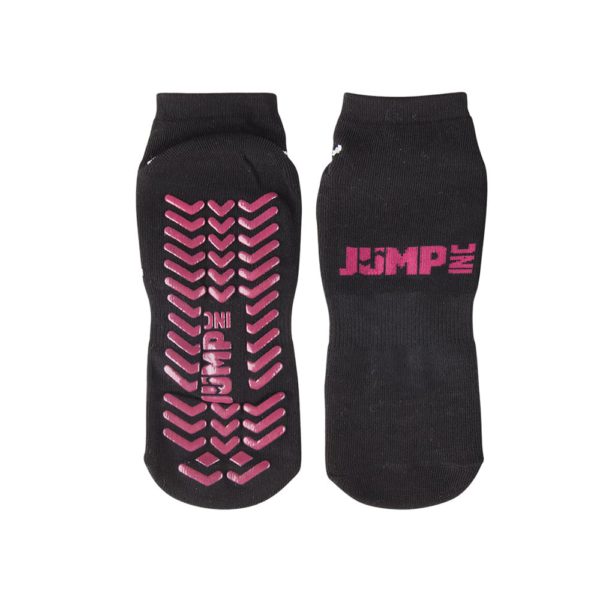 Un par de calcetines de trampolín negros para uso exterior, con patrones de agarre en rosa y el logo "jsmp" en la suela y el costado.