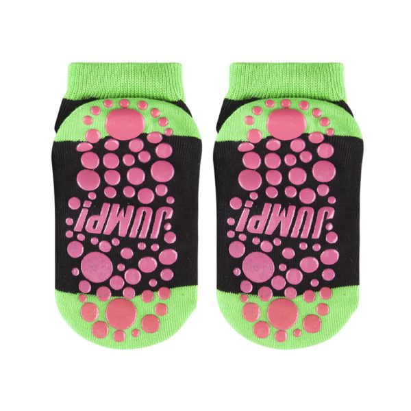Um par de meias trampolim externas pretas e verdes com pontos rosa e padrões de aderência.
