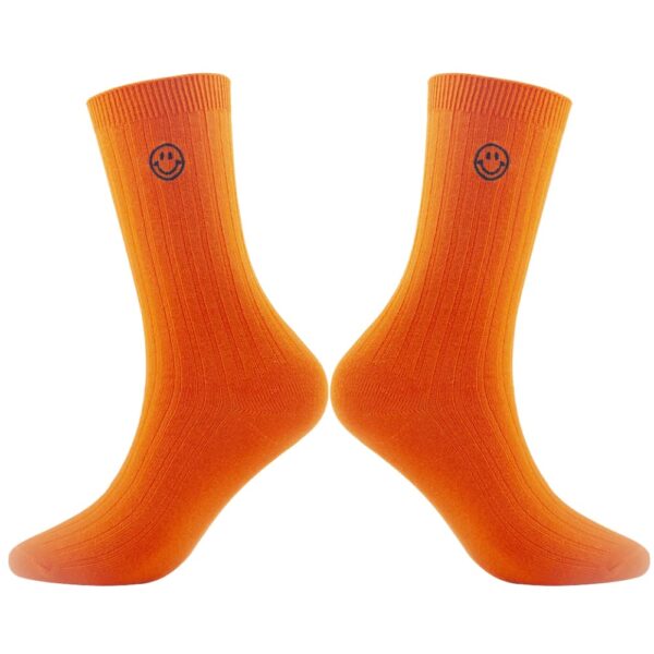 A pair of Custom Embroidered Dress Socks - Personalized Crew Socks with Knitted Design in orange with a smiley face logo on the cuffs.