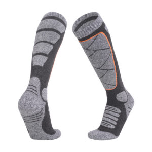 Graue, kniehohe, feuchtigkeitsableitende Wintersportsocken mit verstärkten Mustern und orangefarbenen Akzenten für Halt und Polsterung. Ideal für Wintersport.