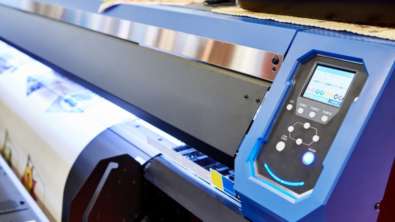 Close-up of large-format inkjet printer’s control panel and printing mechanism, perfect for dye sublimation.