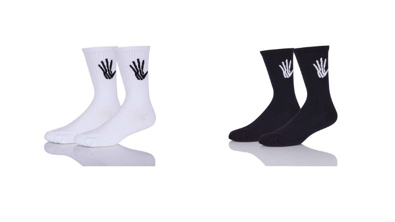 Two pairs of Sinoknit cushioned socks: white with black handprint and black with white handprint, perfect for comfort. White background.