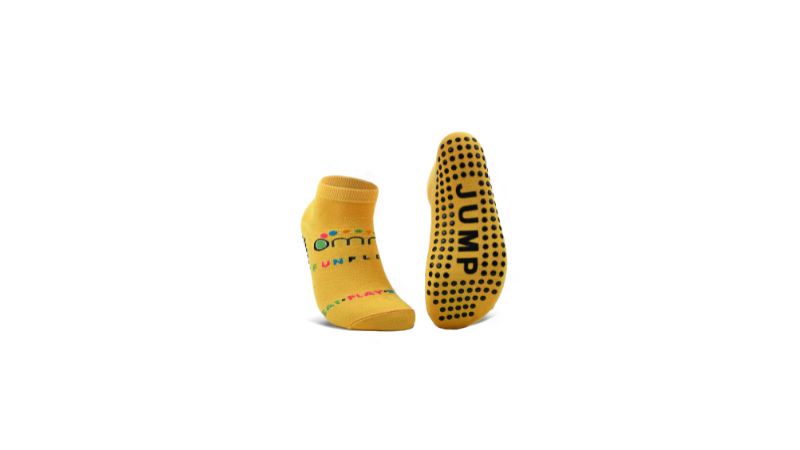 Two yellow grip socks: one with a colorful logo, the other with "JUMP" in black dots on the sole. Ideal for workouts; easy to wash.