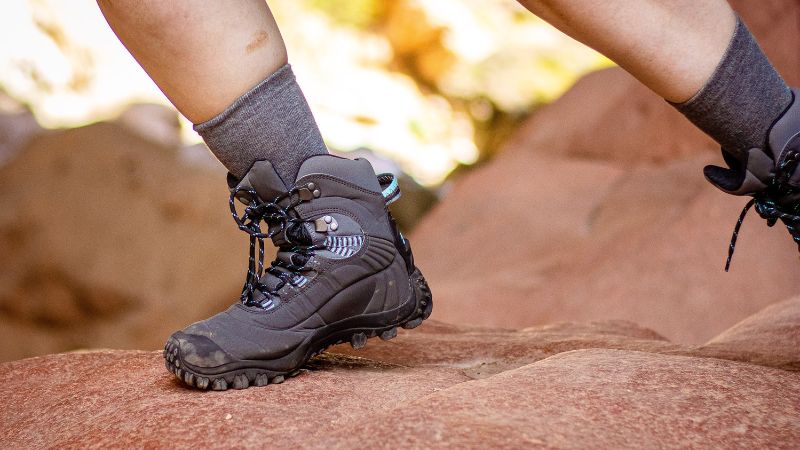 Durable black hiking boot on rocky terrain, designed for outdoor adventures and rugged trails, providing excellent support and traction for outdoor enthusiasts.