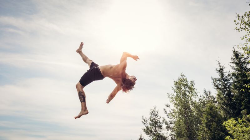 Young man performing acrobatics outdoors during daytime.