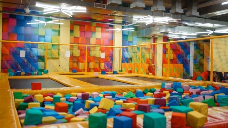 Colorful indoor trampoline park with foam pits, padded walls, and bouncing zones for kids and adults. Safe and fun recreational space designed for active play and physical activity.