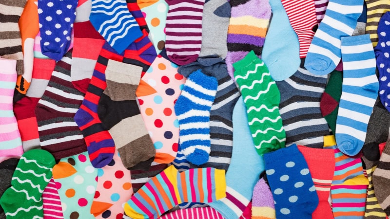 Brightly colored socks with various patterns, including stripes and polka dots, displayed for sock production and manufacturing process.