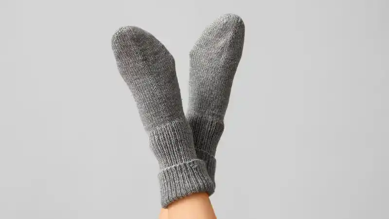 Close-up of gray merino wool socks on a person's feet, showcasing soft, breathable, and warm fabric ideal for outdoor activities and cold weather.