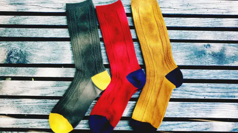 Brightly colored socks in green, red, and yellow with contrasting toe and heel accents, perfect for pairing with shorts for a stylish and comfortable summer look.
